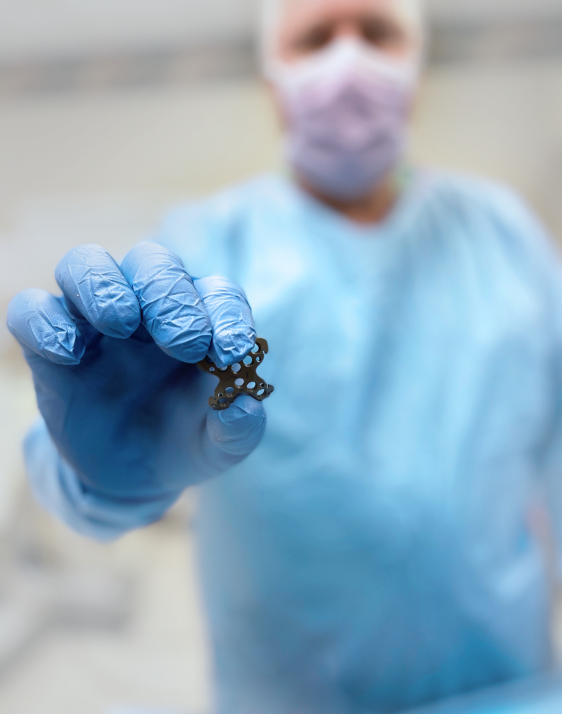 Doctor holding up summit patella plating system.